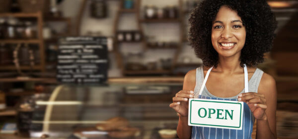 Women Holds Her Open Sign for Her Successful Small Business
